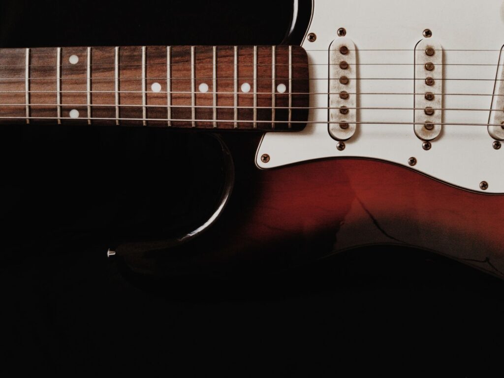 Nahaufnahme einer E-Gitarre mit Saiten, Griffbrett und Tonabnehmern