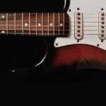 Nahaufnahme einer E-Gitarre mit Saiten, Griffbrett und Tonabnehmern