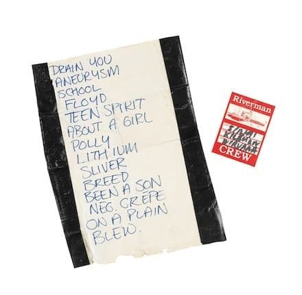 Handgeschriebene Blues-Setlist auf Papier neben einem Riverfront-Crew-Ausweis